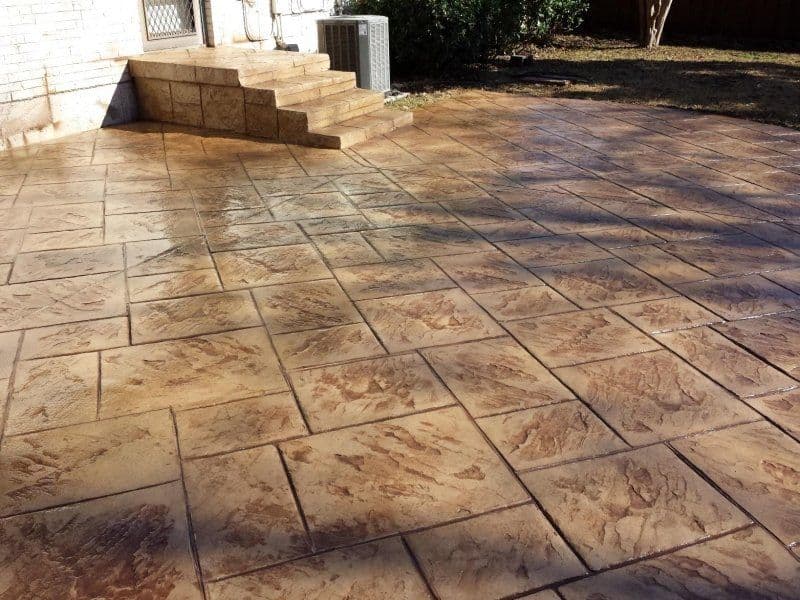 Concrete patio with entry steps by J C Garden Tree Service.
